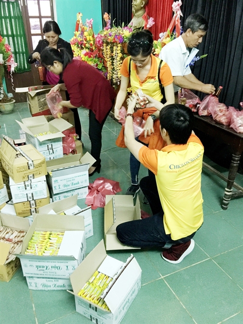 Ban lãnh đạo địa phương hỗ trợ phân phát quà cho người dân